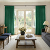 Rich green velvet room darkening curtains with elegant pleats and luxurious drape.
